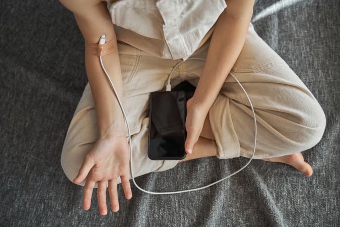 Unrecognizable kid charging from cellphone