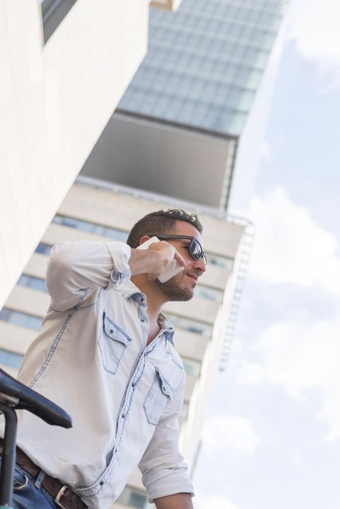 Male taking phone call while standing in front of building