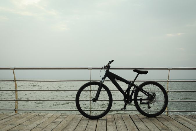 Bicycle on wooden boardwalk outdoors, space for text