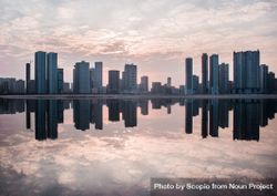 Sharjah city skyline reflection on water at sunset in UAE 41O1N0