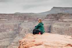 Female relaxing on cliff and admiring picturesque view