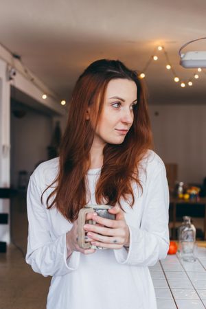 Woman with a mug of a warm drink in her apartment