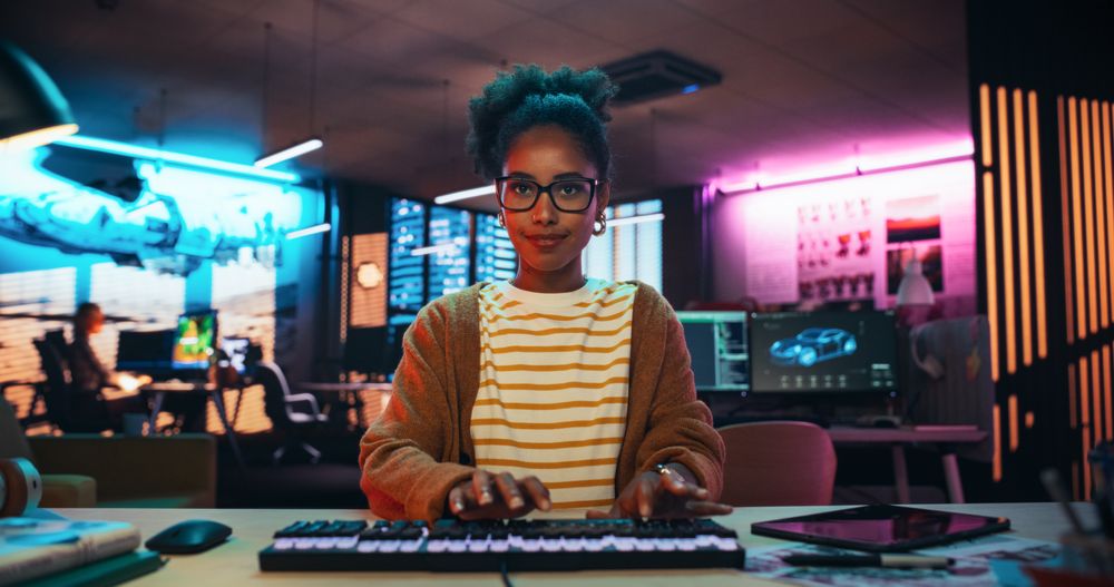 Portrait of a Black Female Developer Writing Code in a Creative Office with Neon Lights.