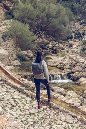 Woman admiring streaming creek in mountains