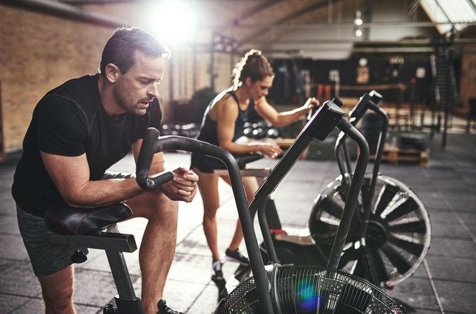Exhausted man and woman after completing workout on stationary bikes