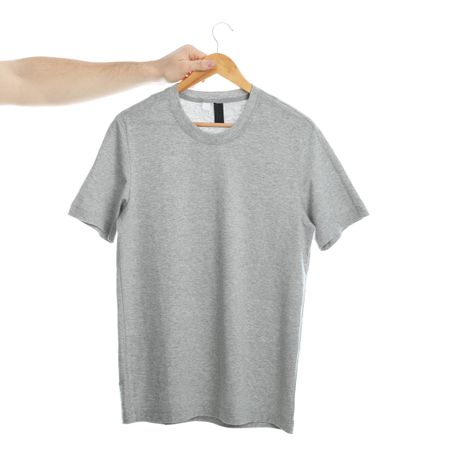 Man holds a hanger with blank t-shirt, isolated on plain background