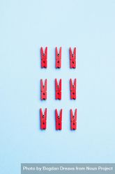 Red clothes pins on light blue background bYgWD5