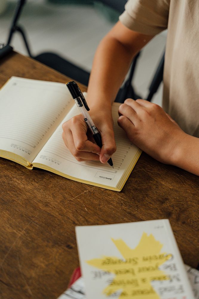 Cropped image of young student writing on a notebook