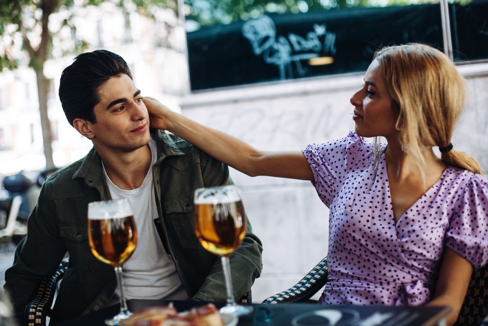 Happy young couple drinking beverages outdoors