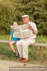 Man in cap and bored child reading newspaper outdoors 4ABwEb