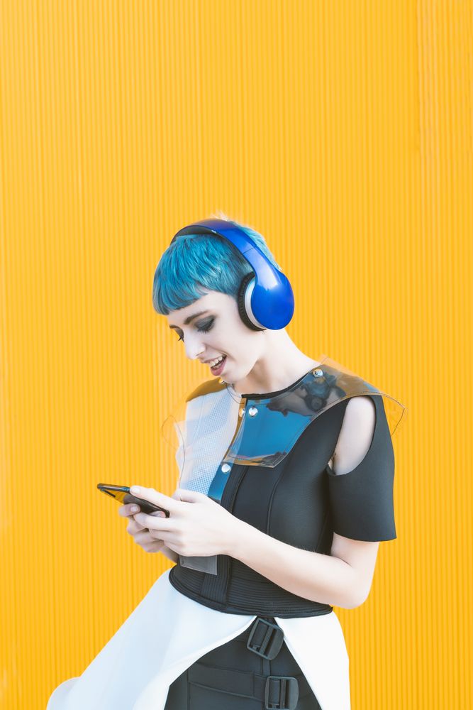 Futuristic woman using smartphone and listening to music