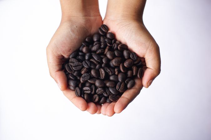 Whole coffee beans in hand