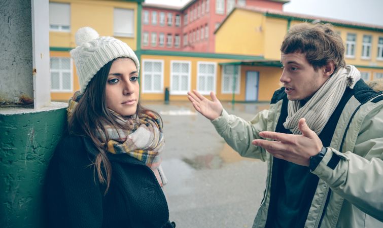 Couple in winter clothes having a difficult conversation outside