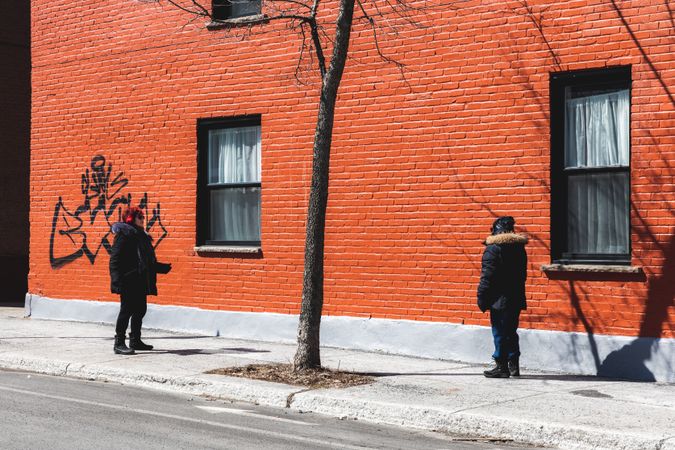 MONTREAL, QUEBEC, CANADA – March 27 2020- Two women having a conversation on the sidewalk