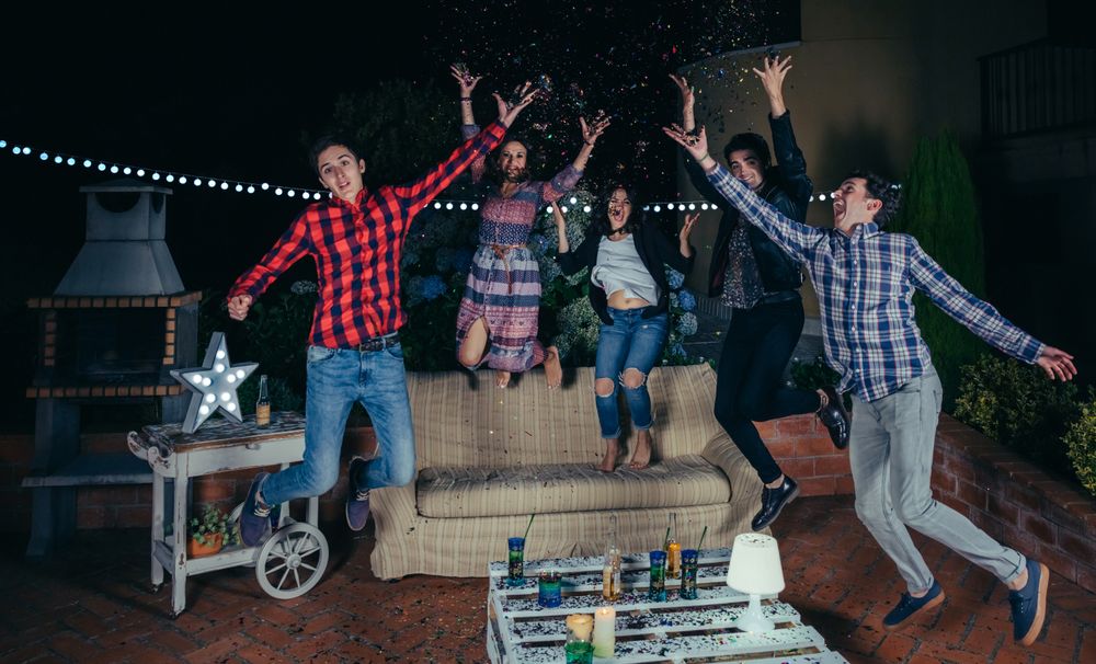 Happy friends throwing confetti at party