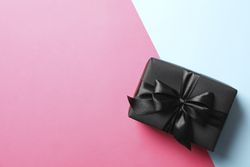 Gift box with dark bow on two tone background