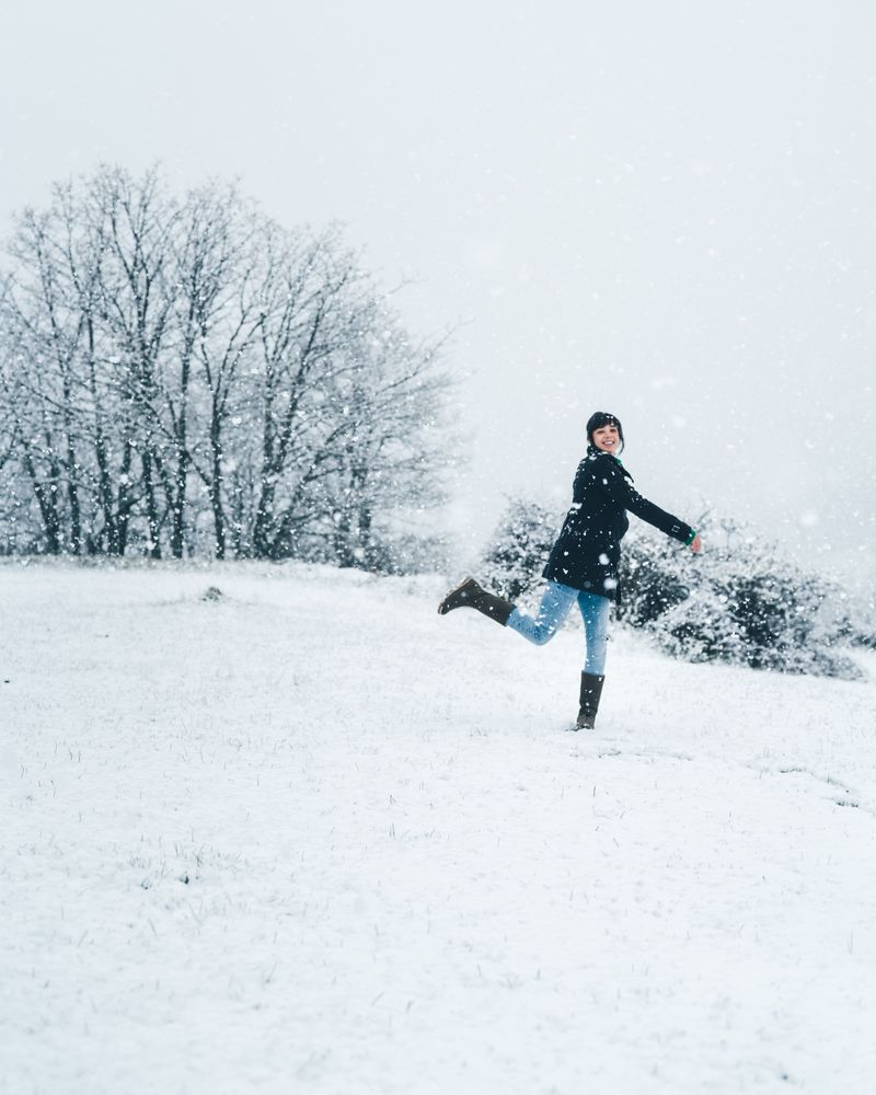 Woman playing with snow on winter field
