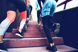 Rear shot of people leg’s running up red stairs