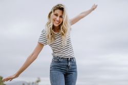 Happy woman walking with spread arms