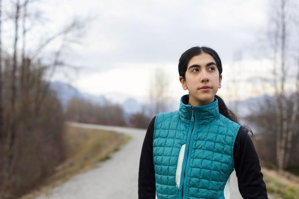 Young woman looking to her right while standing on a trail