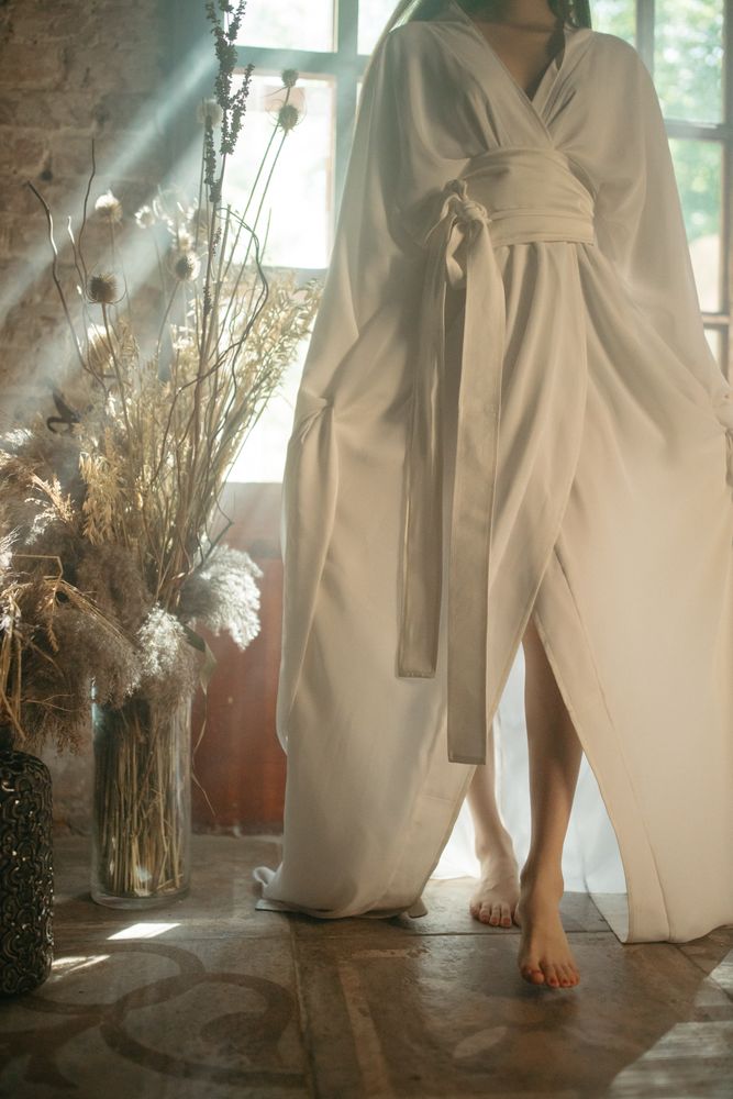 Cropped image of woman wearing light garment standing indoor