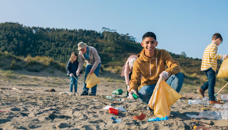 Young man cleaning the beach