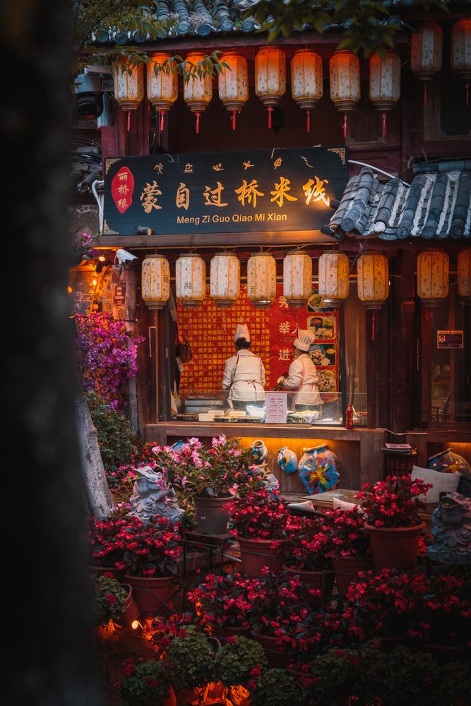 Exterior view of a restaurant decorated with paper lanterns at night