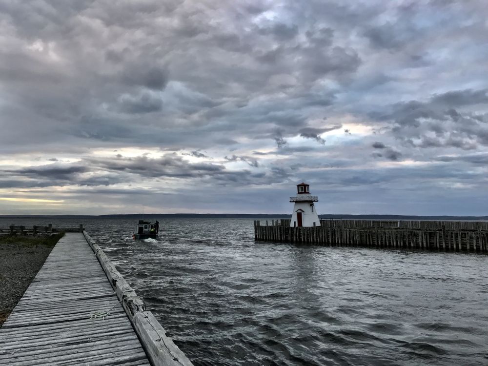 Lighthouse on sea port during cloudy day