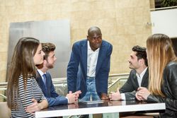 Man using a digital tablet leading his corporate team during a meeting