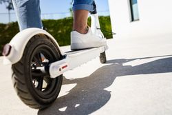 Back of back wheel of scooter with female driver