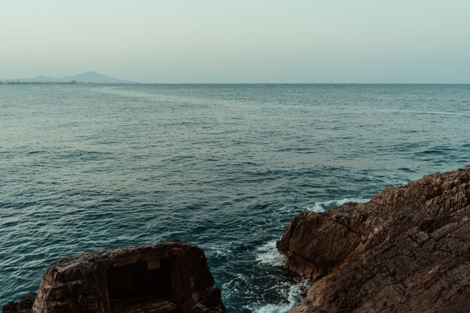 Sea waves hitting rocky cliff