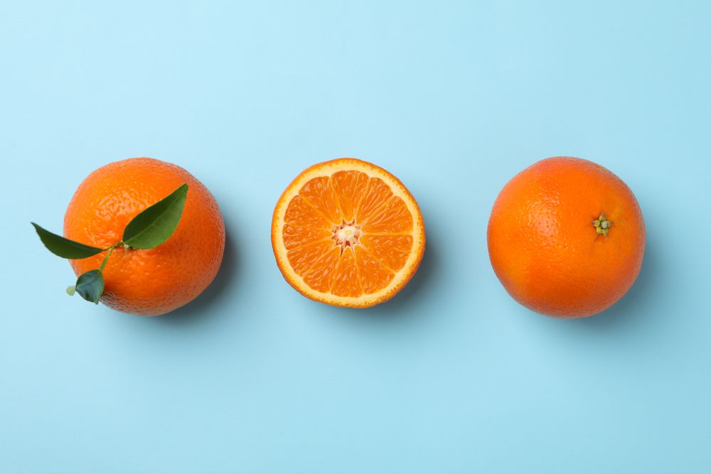 Ripe sweet mandarins on blue background, top view