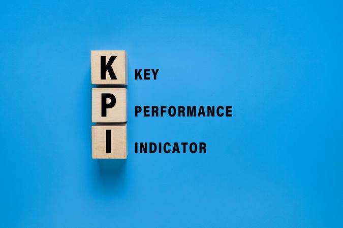 KPI letter symbol on wooden blocks isolated on blue background. concept of business key performance indicator