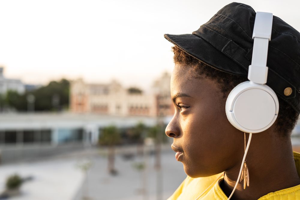 Peaceful female enjoying music and relaxing on balcony