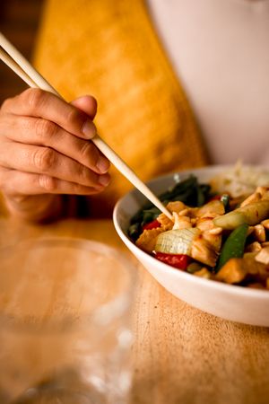 Female eating bowl of cooked appetizing diet dish