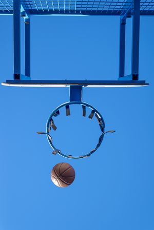 Street basketball ball falling into the hoop, vertical