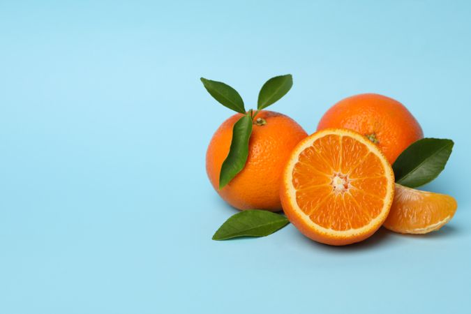 Ripe sweet mandarins on blue background, space for text