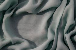 Nude green fabric wavy crumpled background texture with copy space.