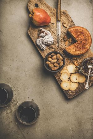 Cheese plate with glasses of red wine on concrete