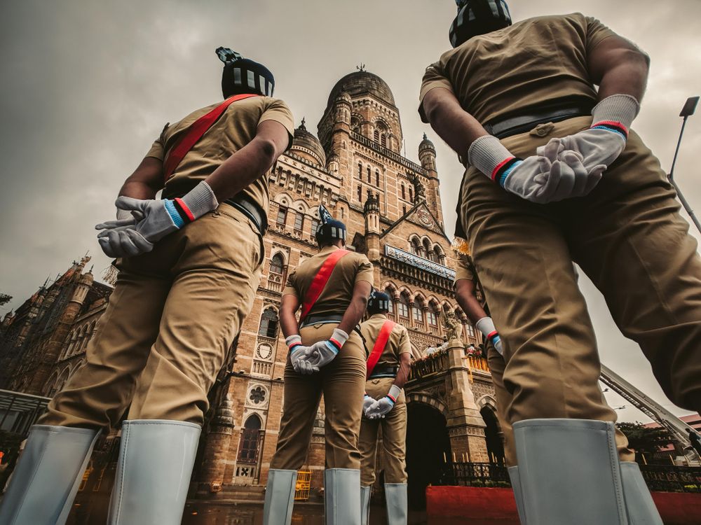 Back view of Indian soldiers standing with respect against The Secretariat Building in New Delhi, India