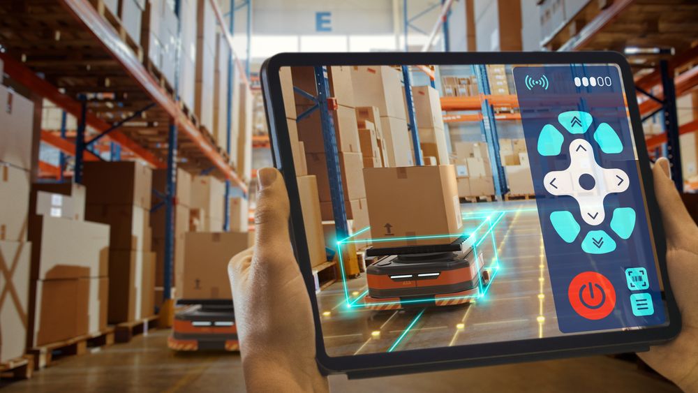 Future Technology Concept: Worker Holding Tablet With Remote Control AR Application For Automated Retail Warehouse AGV Robot with Infographics.