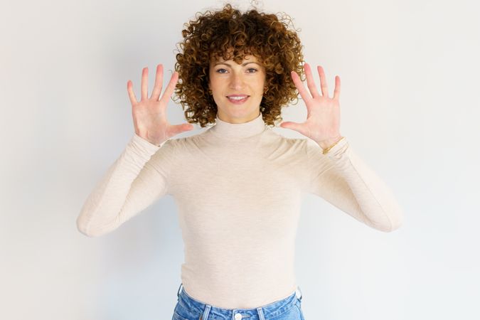 Woman in casual clothes holding up both hands