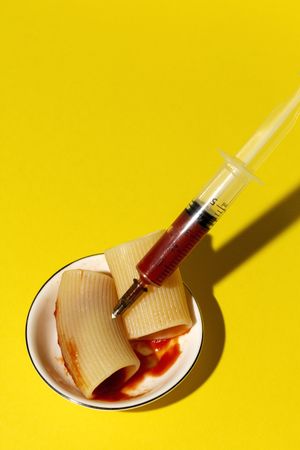 Stuffed pasta with red sauce in syringe