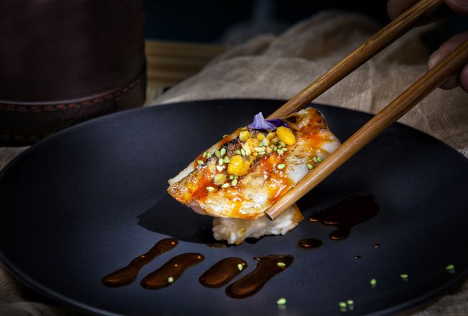 Tasty sushi poured with sauce in sticks