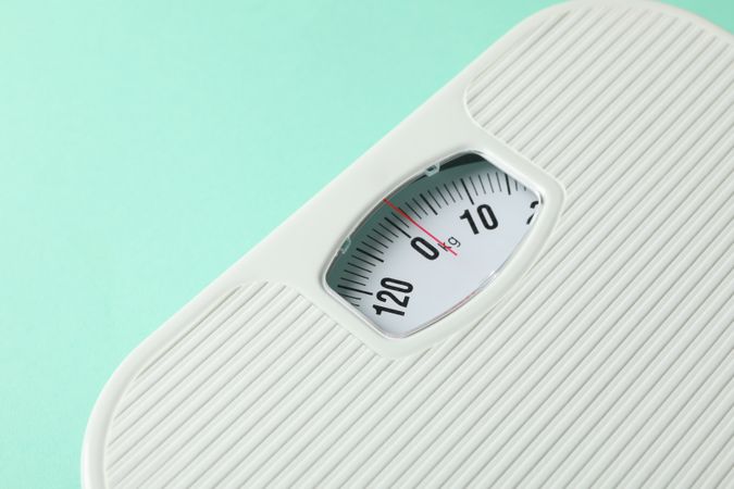 weight scales on mint background. Weight loss concept
