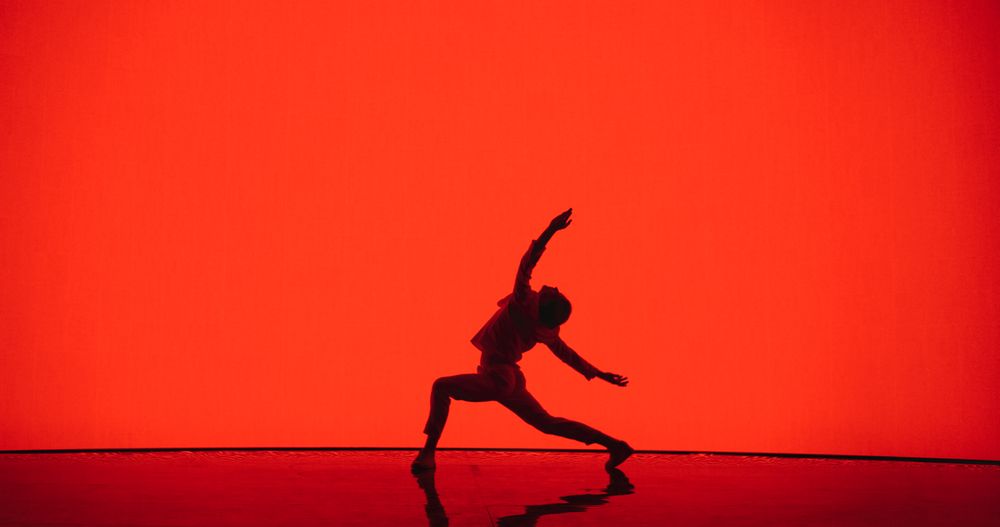 Male Dancer in White Clothes Unleashing an Energetic Fusion of Styles with Powerful Modern Dance Choreography