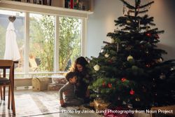 Mother and son sitting by Christmas tree at home 48A8Yb