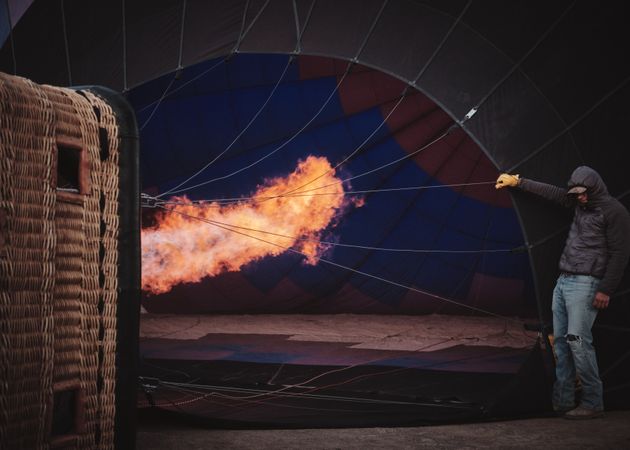 Man next to fire filling up hot air balloon