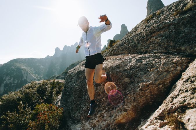 Man jumping down hill on a sunny day