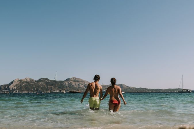 Happy couple walking on sea